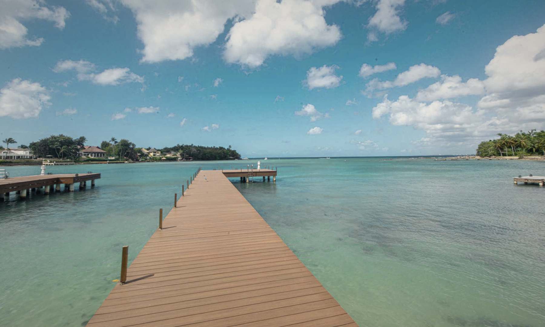 A dock running out over clear water toward the open sea