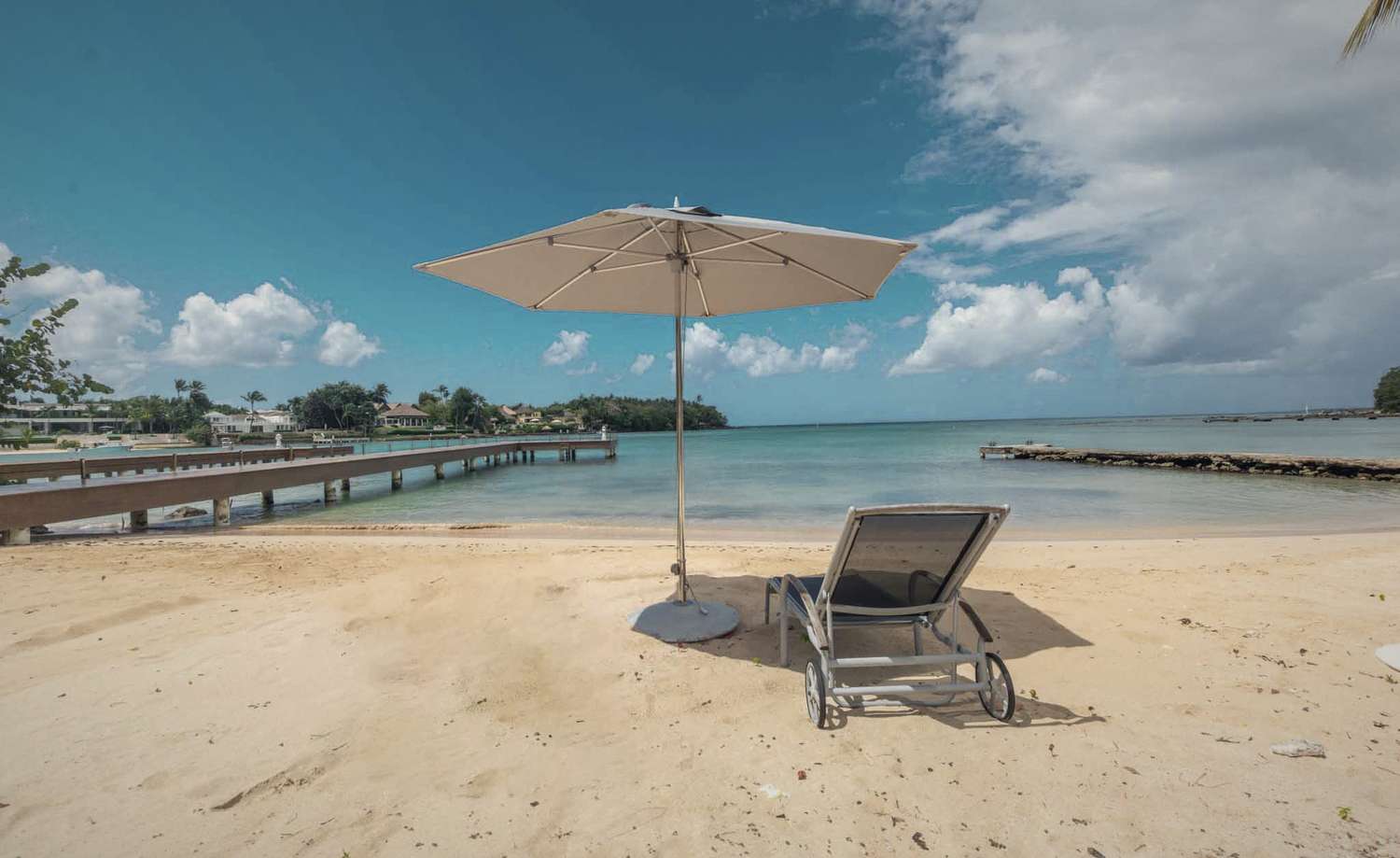 A single parasol and lounger on an empty beach